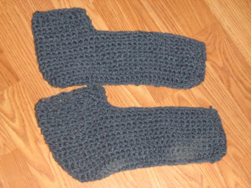 A pair of crochet greyish-blue slippers.