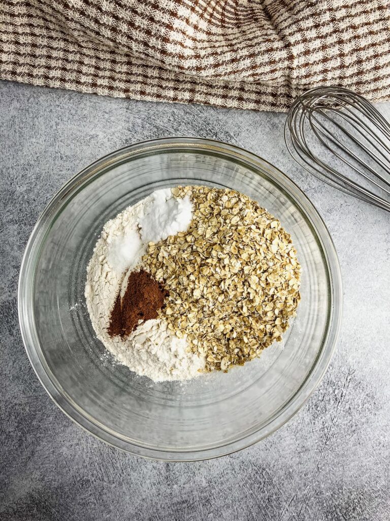 Mixing bowl with flour, quick oats, salt, ground cinnamon, and baking soda.