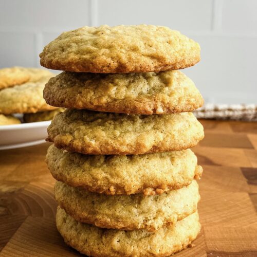Stack of homemade soft and chewy oatmeal cookies on a wooden counter.