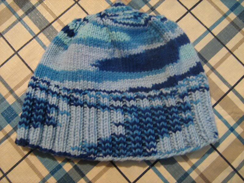 Blue knitted baby hat laying on a table.