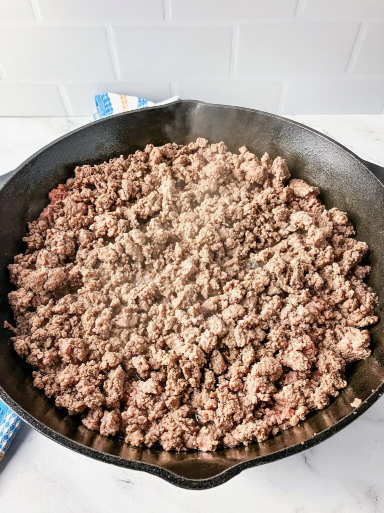Ground beef cooking in a skillet.