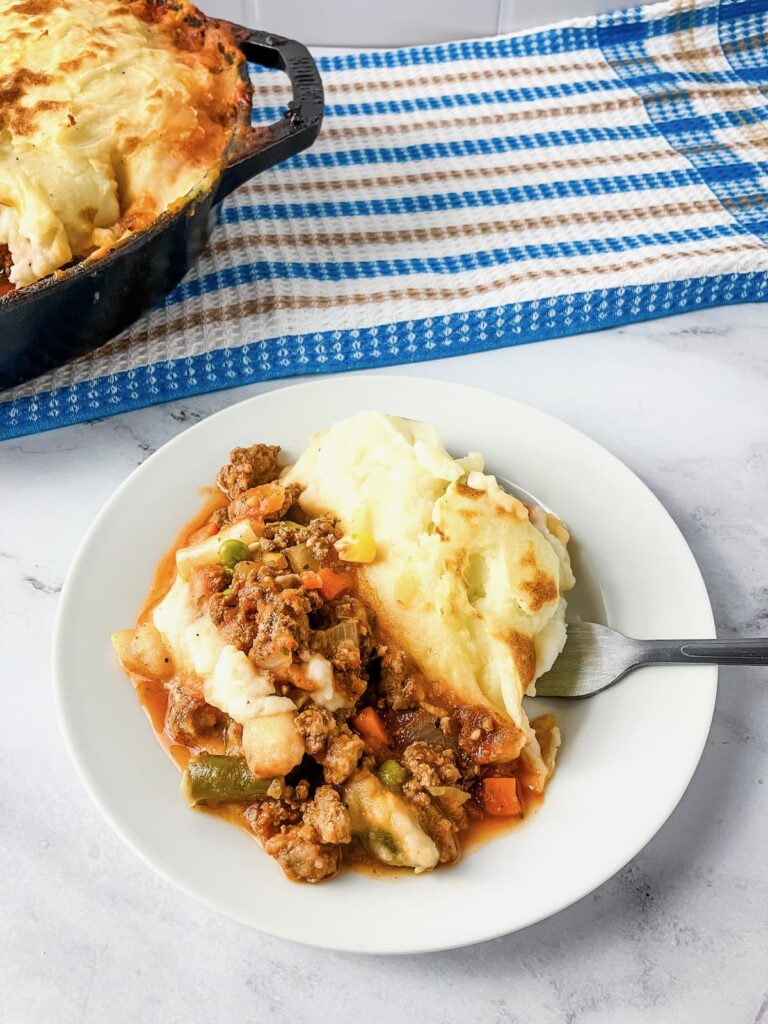 White plate with a serving of Shepherd's pie.
