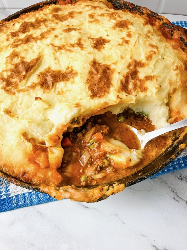 Skillet Shepherd's pie with a spoonful removed to see inside.