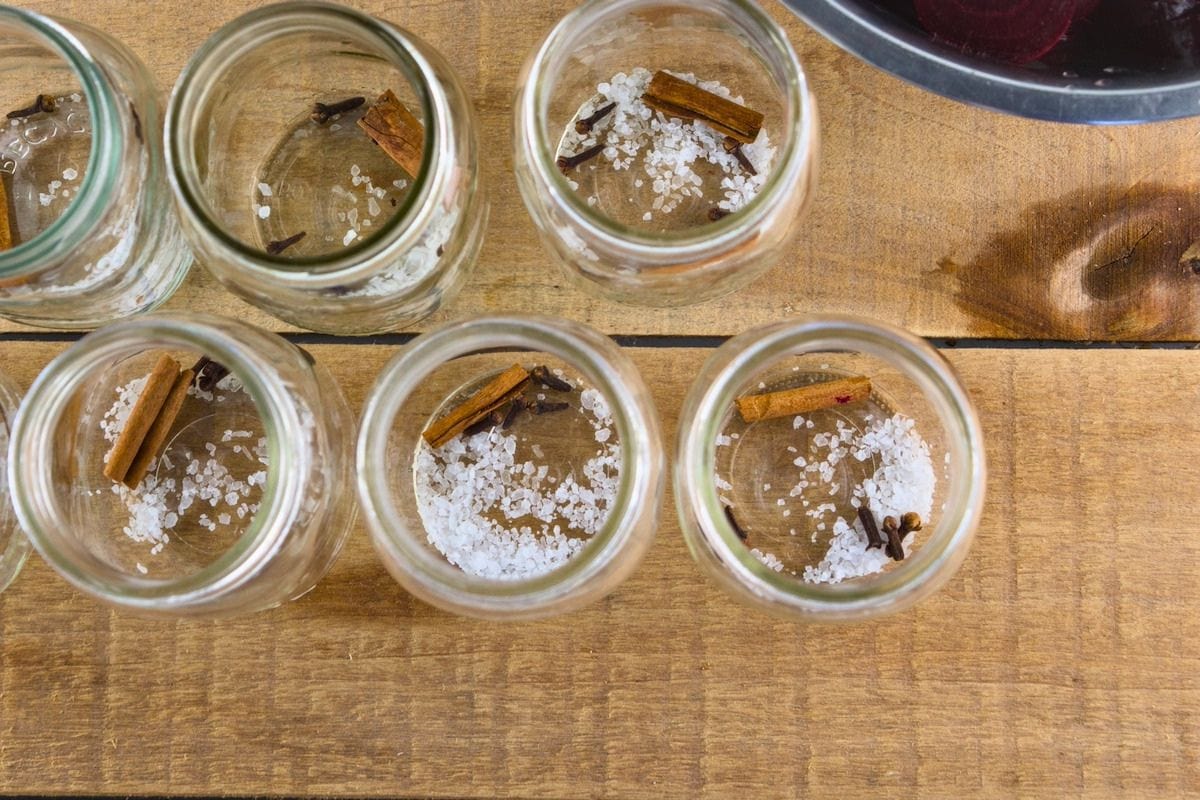 Spices and salt are divided between the canning jars.
