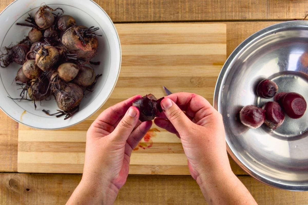 Peeling the skin off cooked beets.