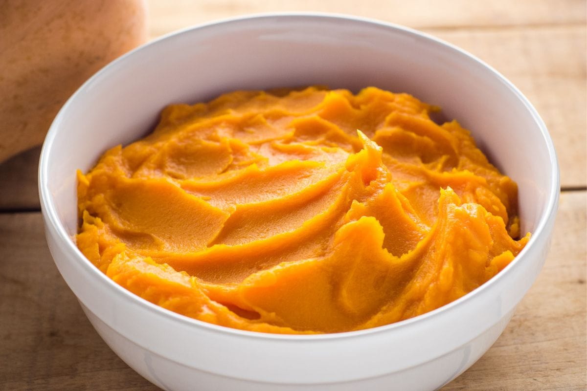 Homemade butternut squash puree in a white serving bowl.