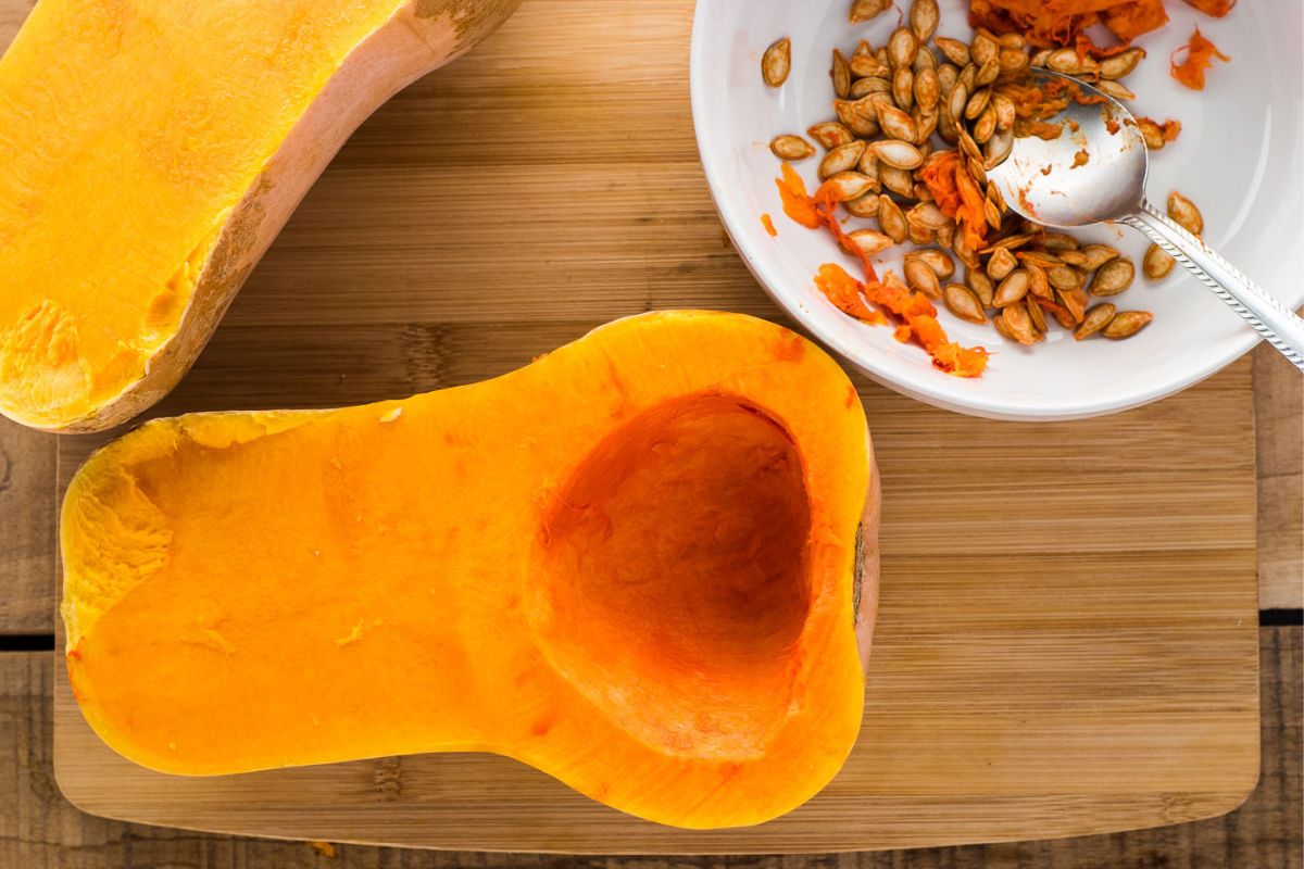 Butternut squash with seeds and pulp removed on a cutting board.