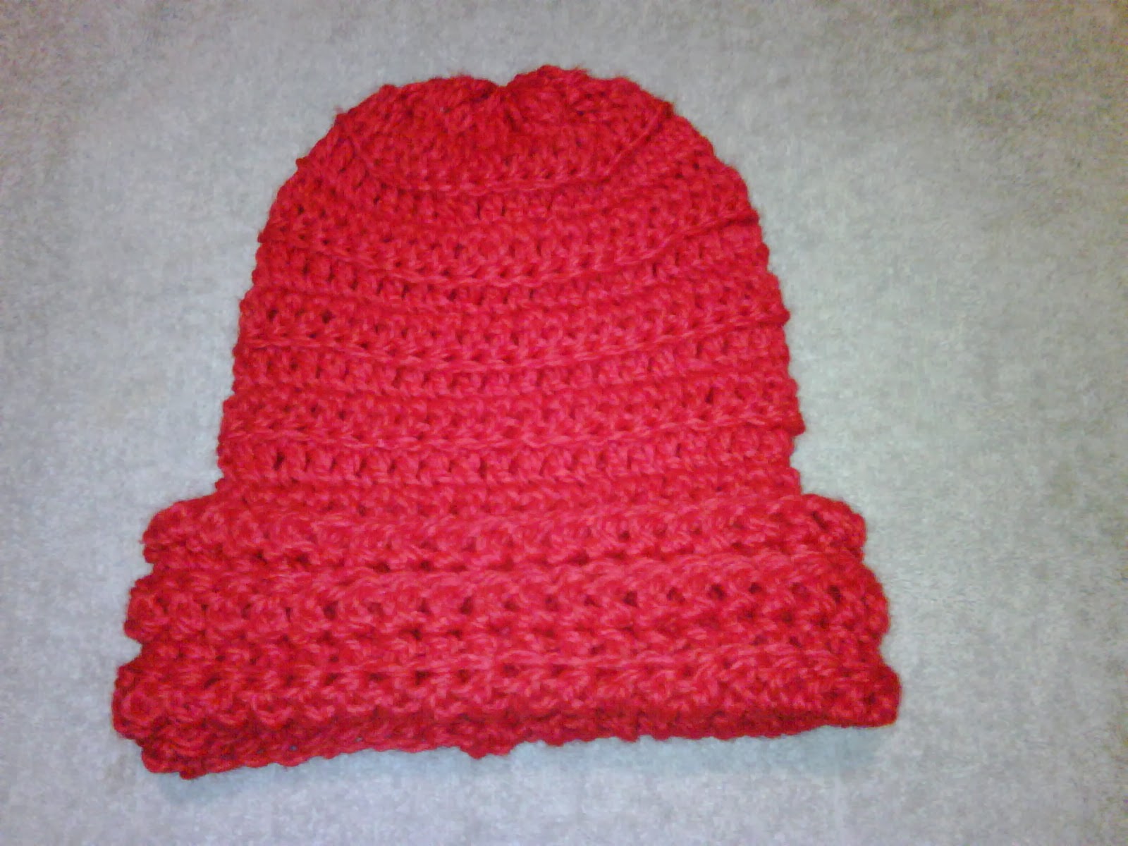 A red crochet hat for a child.