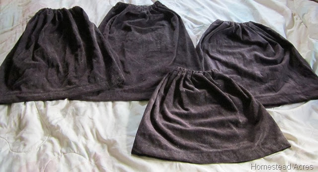 Four homemade skirts laying on a bed.