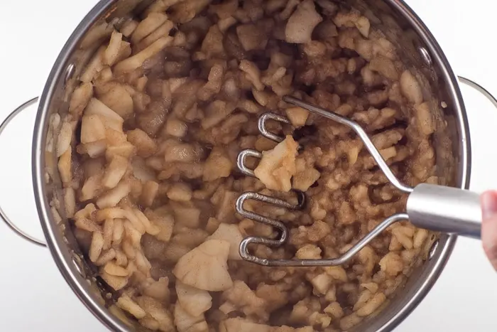 Mashing apples for sauce.