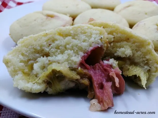 Rhubarb muffins sliced open on a plate.