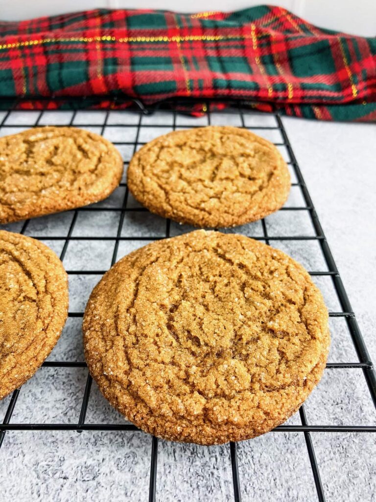 Chewy ginger molasses cookies on a cooling rack.