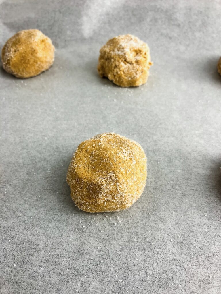 Cookie dough balls on a baking sheet.