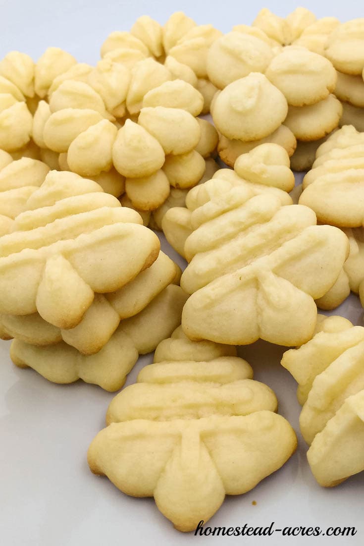 Spritz cookie press cookies shaped like trees and flowers on a serving plate.