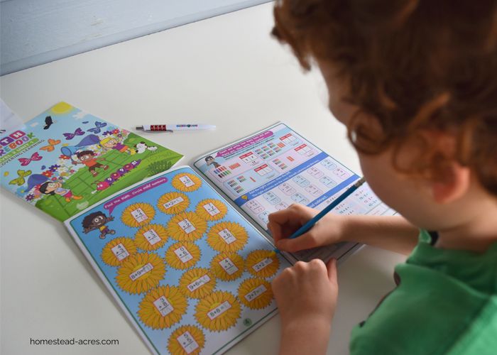 A young boy working on math in a workbook.