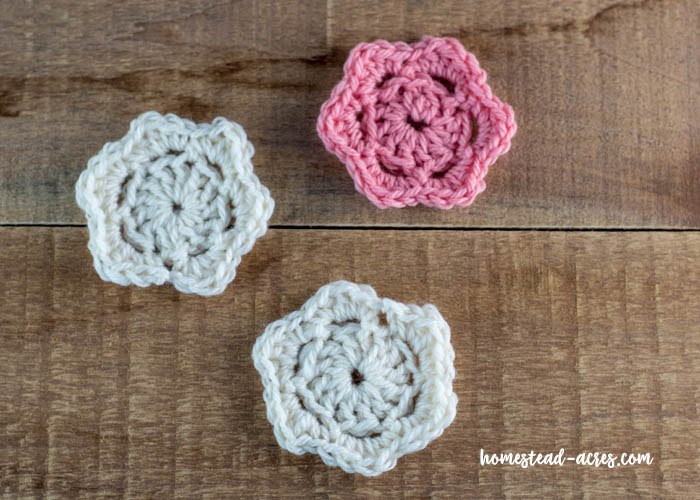 Quick and easy crochet flowers laying on a wooden table.