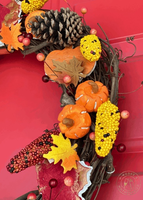 Fall wreath with handmade clay pumpkin and corn ornaments.