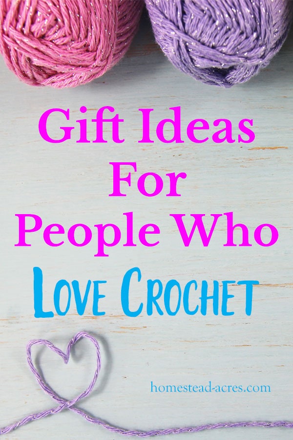 Pink and purple balls of yarn on a wooden table with purple yarn forming a heart. Overlaid text reads Gift Ideas For People Who Love Crochet.