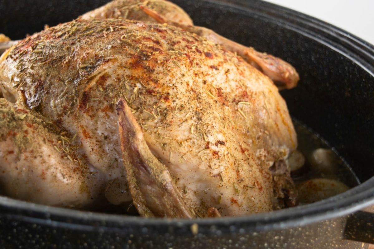 Seasoning a frozen turkey with herbs.
