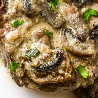 Pork chop covered in a creamy mushroom sauce.