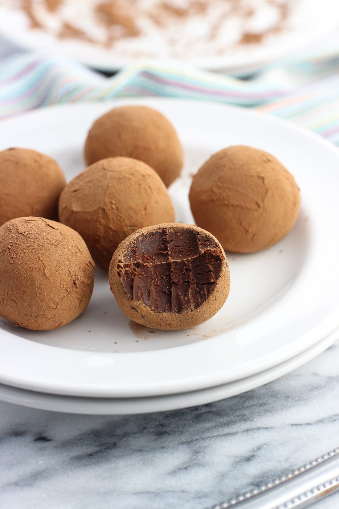 Chocolate Irish cream truffles on a white plate.