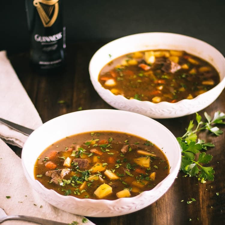 Two white bowls filled with Irish stew.