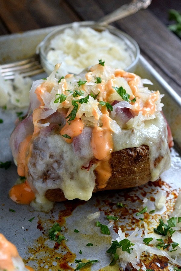 Reuben stuffed baked potato on a backing sheet.