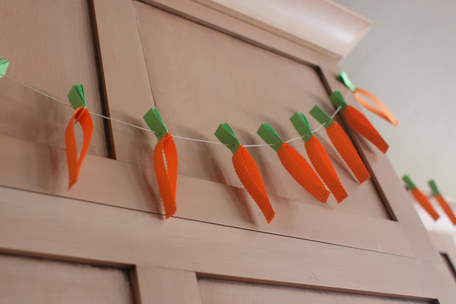 DIY carrot garland hanging on a wall.