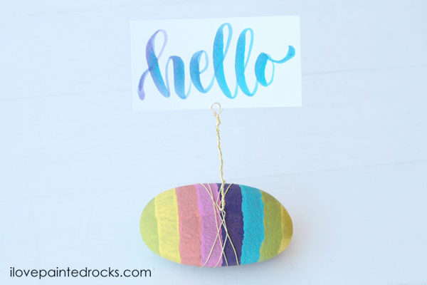 Rainbow striped painted rock photo holder.