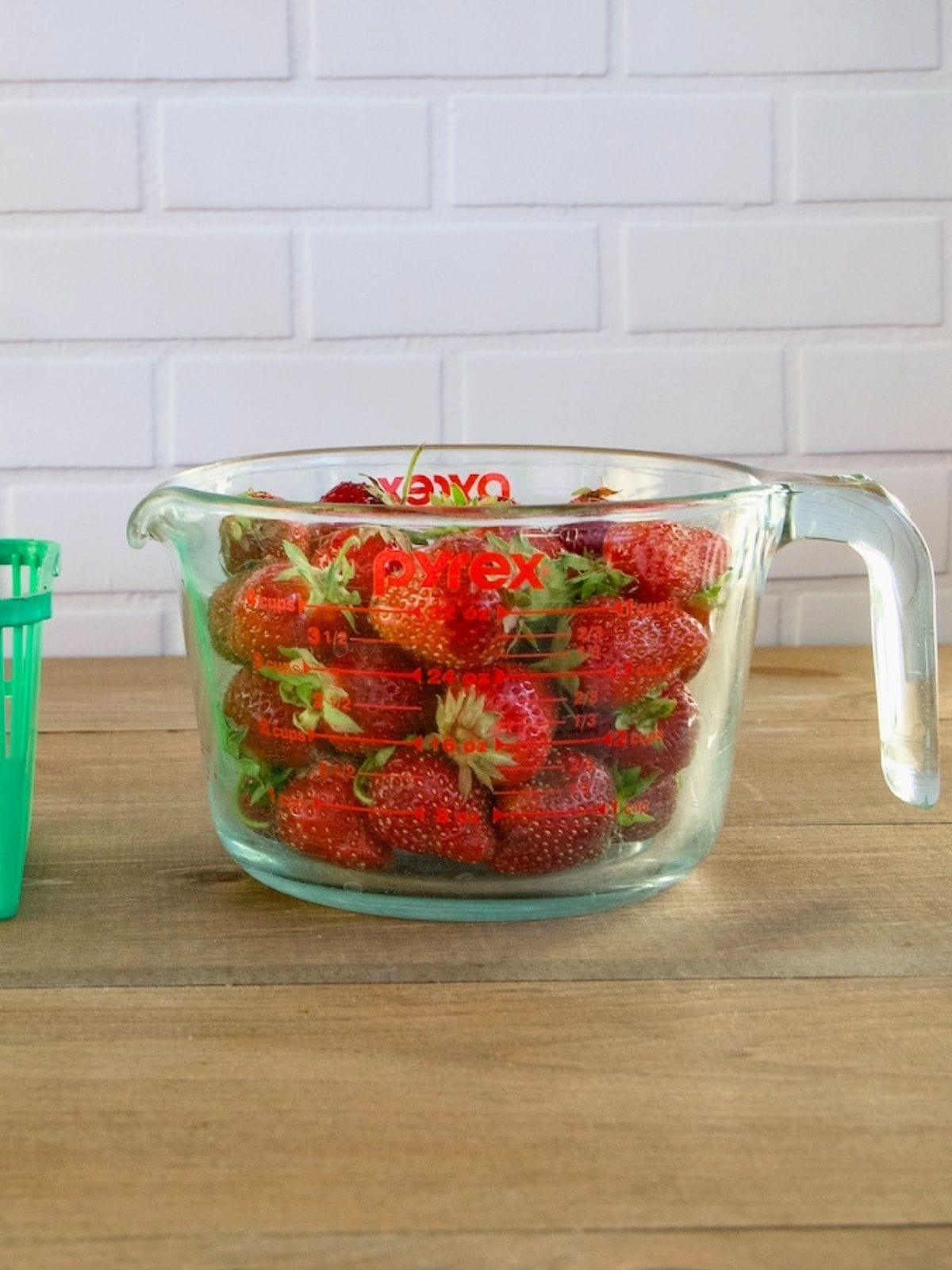 A quart basket of strawberries was poured into a measuring cup.