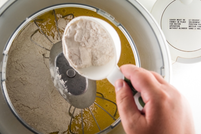 Combining dry and wet ingredient in a mixer bowl.