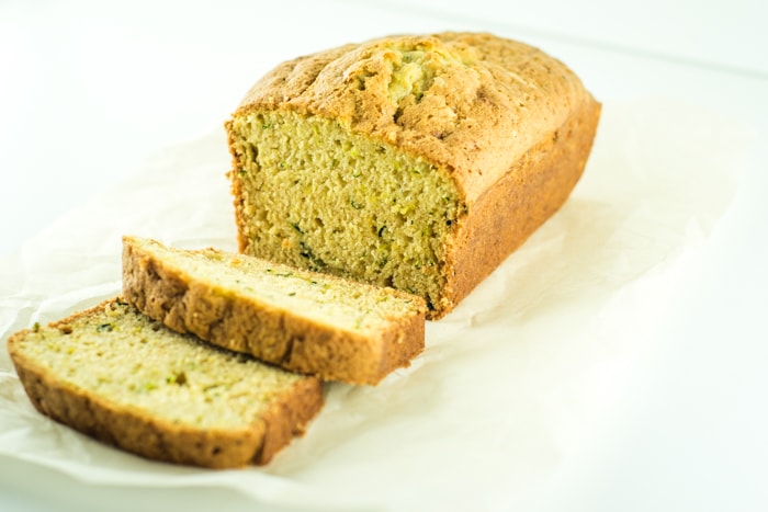 Homemade sliced zucchini bread on parchment paper.