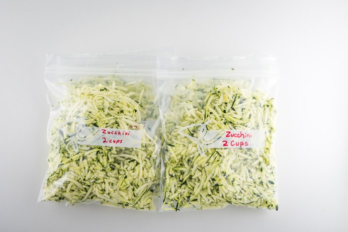 Shredded zucchini in freezer bags ready to freeze.