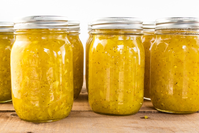 Jars filled with ripe cucumber relish ready to can.