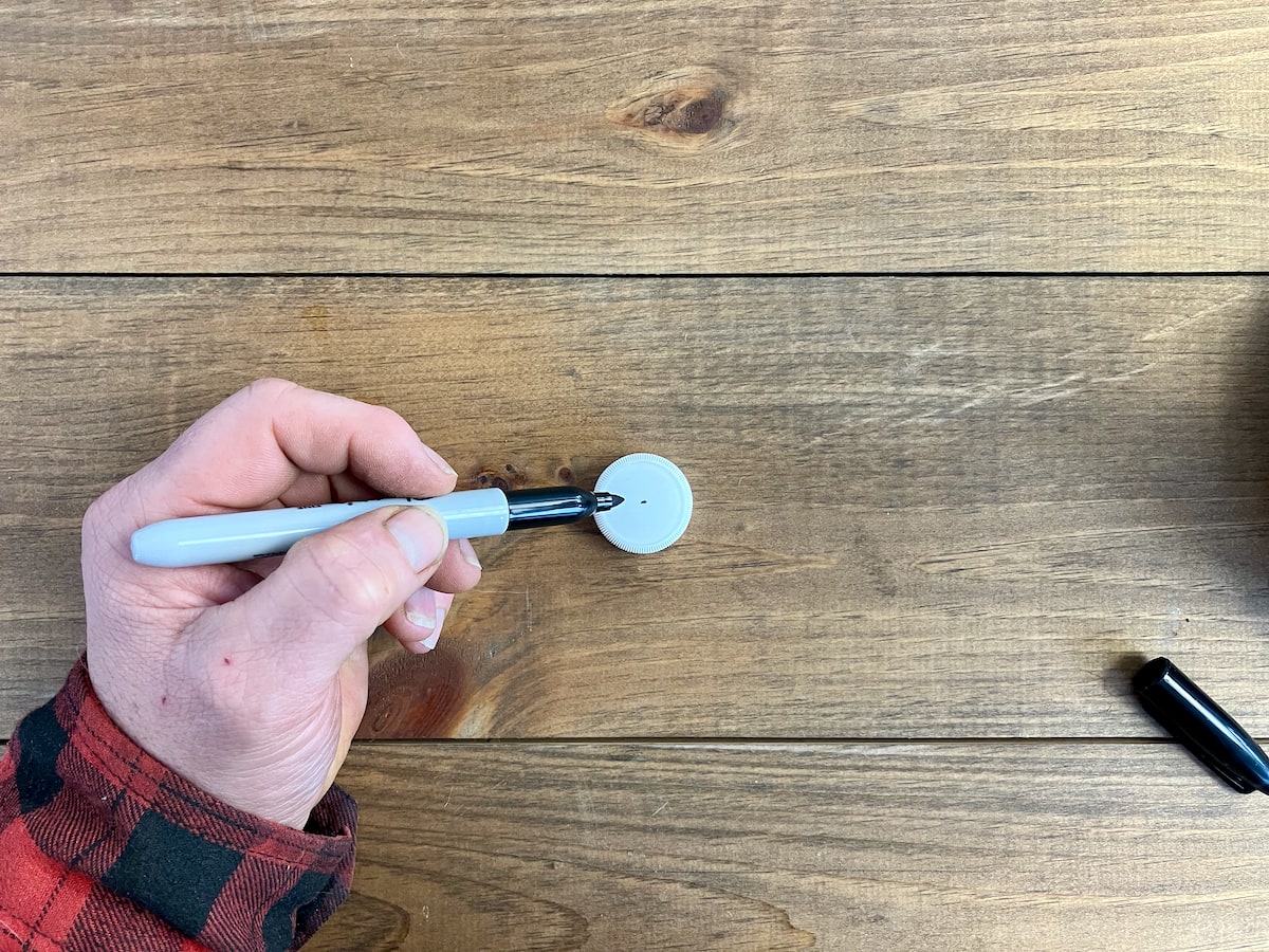 Marking drill holes on the bottle lid.