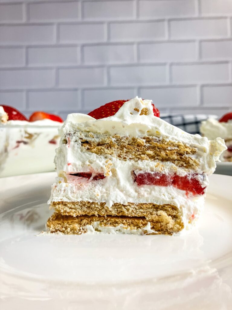A slice of strawberry icebox cake on a white plate.