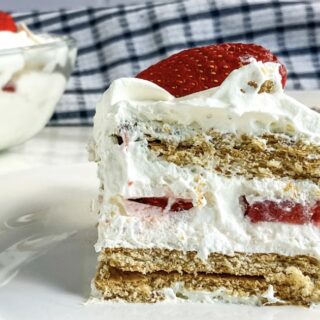 A slice of strawberry icebox cake on a white plate.