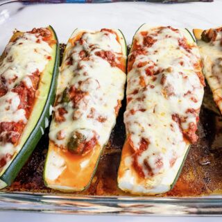 A glass baking dish filled with stuffed zucchini boats.