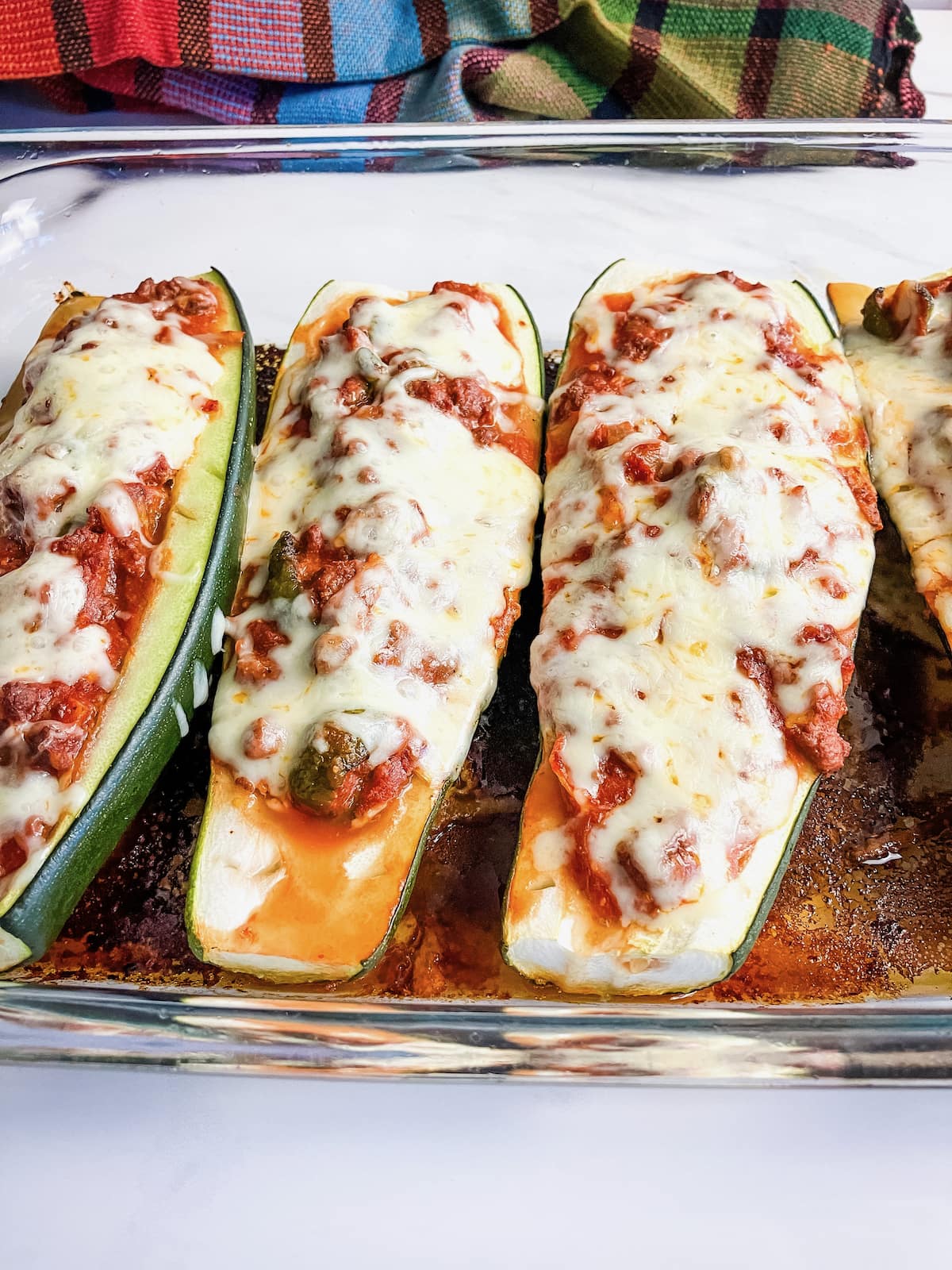 A glass baking dish filled with stuffed zucchini boats.