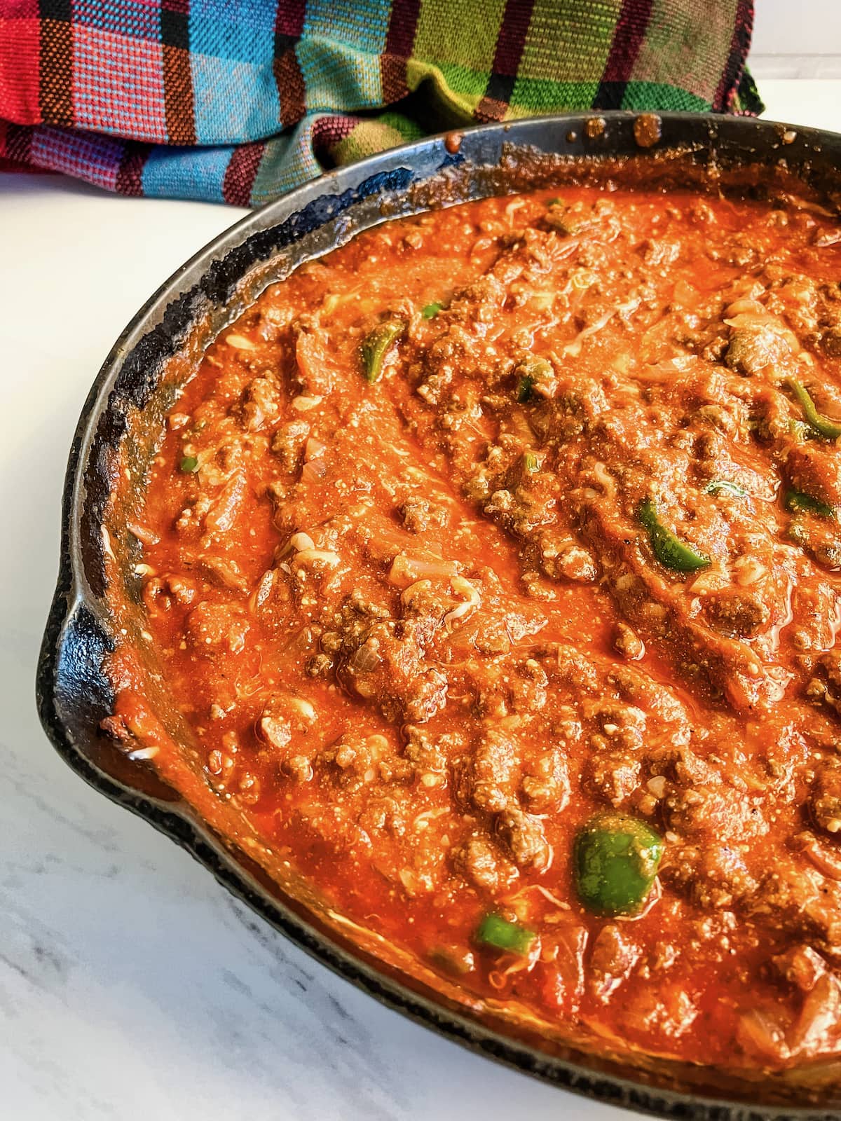 Cast iron skillet filled with a homemade meat sauce.