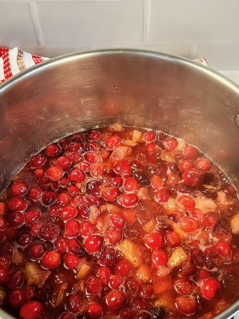 Cranberry pear sauce cooking in a saucepan.