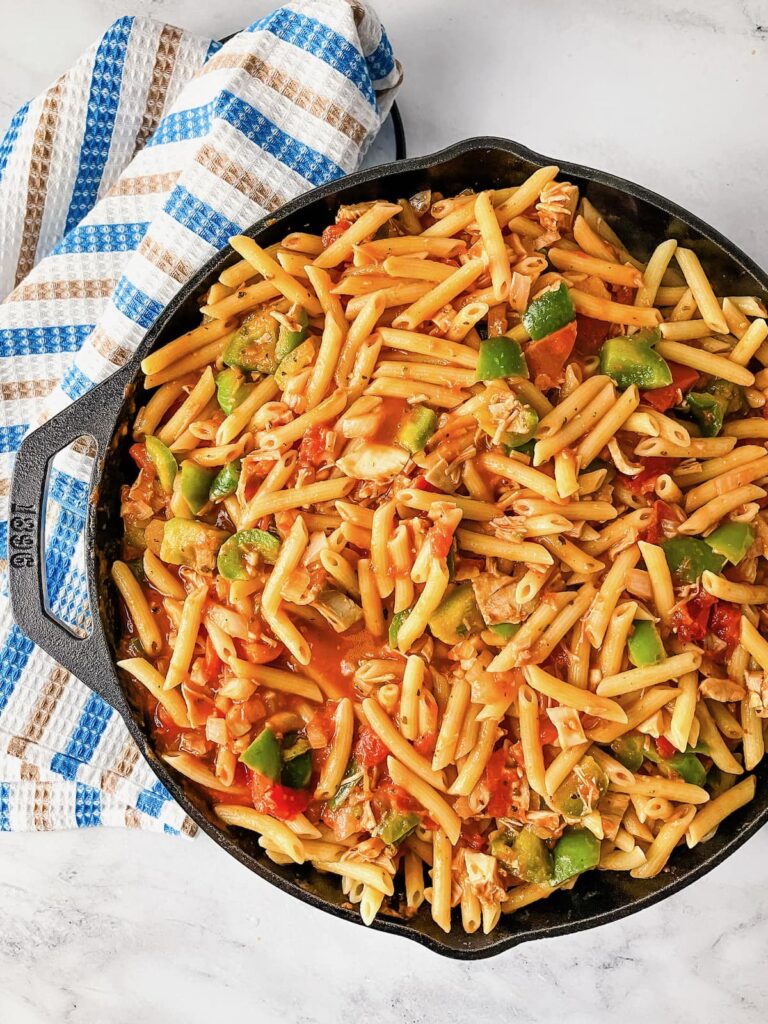 Cast iron skillet filled with pasta and a turkey meat sauce.