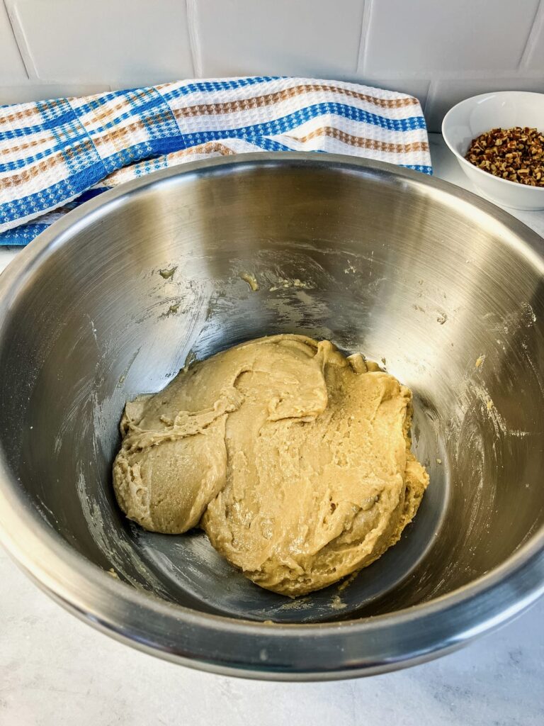A mixing bowl with butter pecan cookie dough.