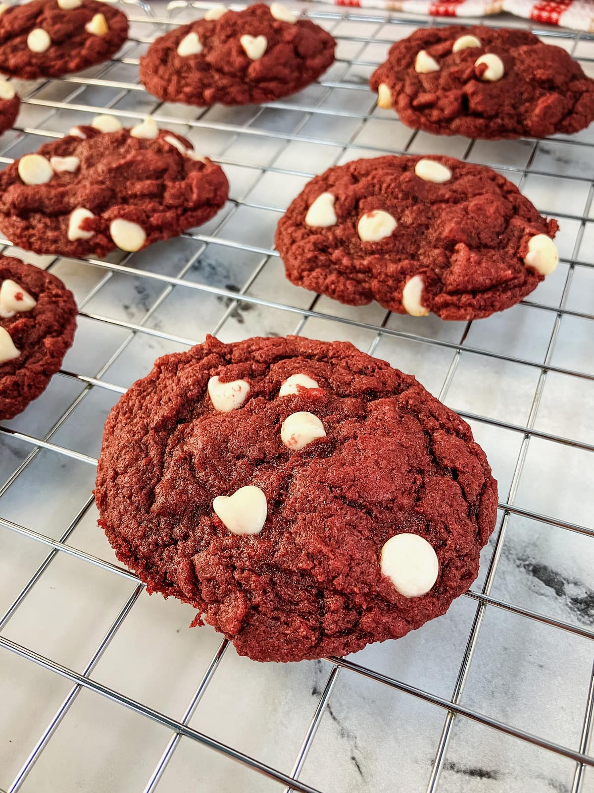 Red velvet cookies cooling on a wire rack.