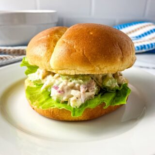 A sandwich bun filled with homemade turkey salad and fresh lettuce.