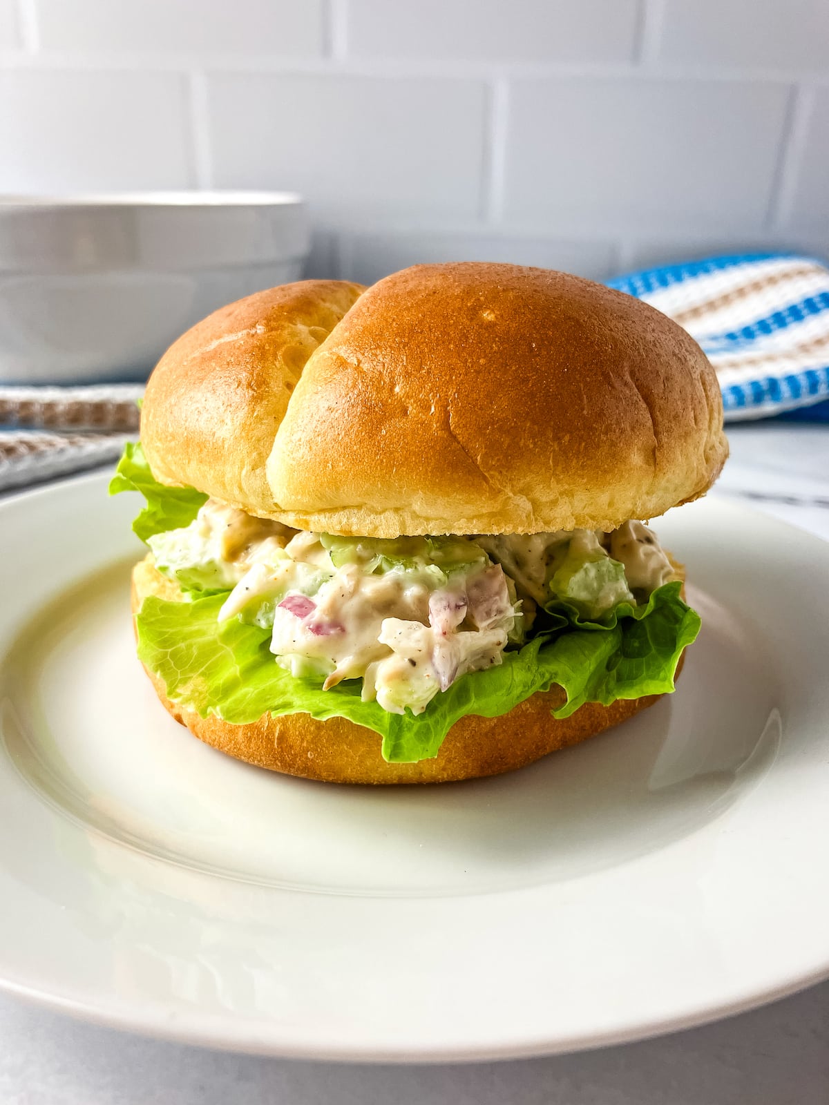 A sandwich bun filled with homemade turkey salad and fresh lettuce.