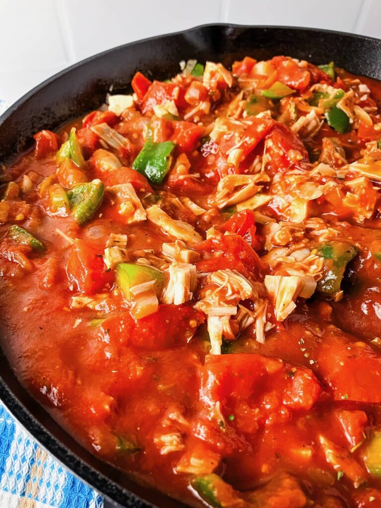 Turkey and tomato meat sauce cooking in a skillet.