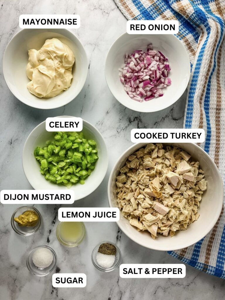 Turkey salad ingredients in small bowls, diced turkey, onion, celery, mayonnaise, dijon mustard, lemon juice, sugar, salt, and black pepper.
