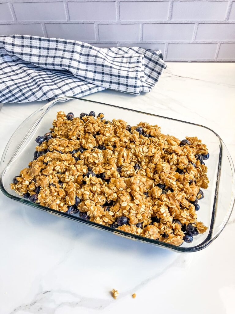 Homemade blueberry crisp with unbaked topping.
