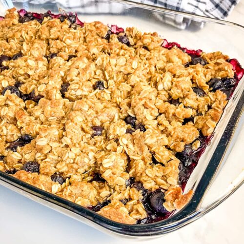 Homemade blueberry crisp in a glass baking pan.